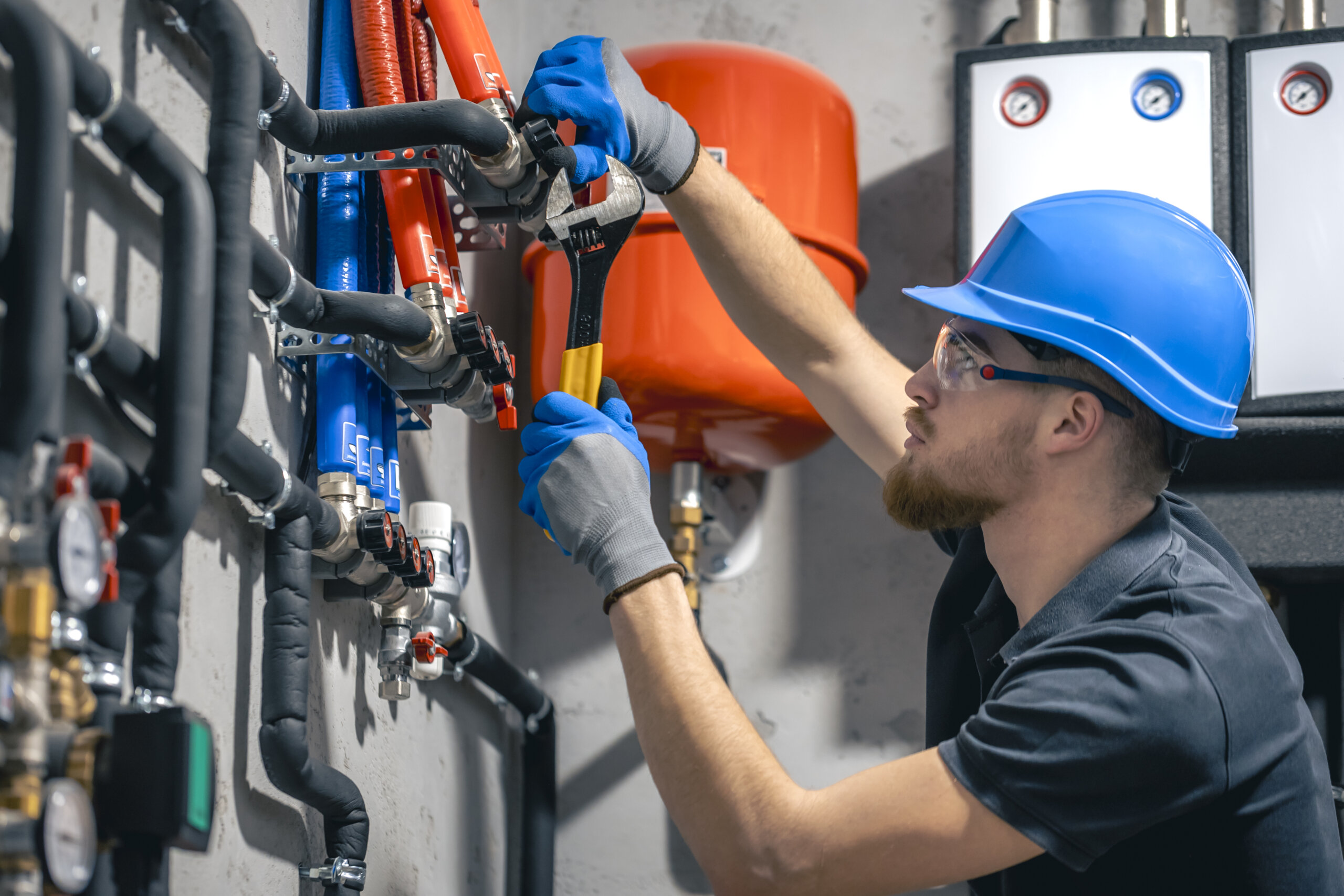 man-installs-heating-system-house-checks-pipes-with-wrench